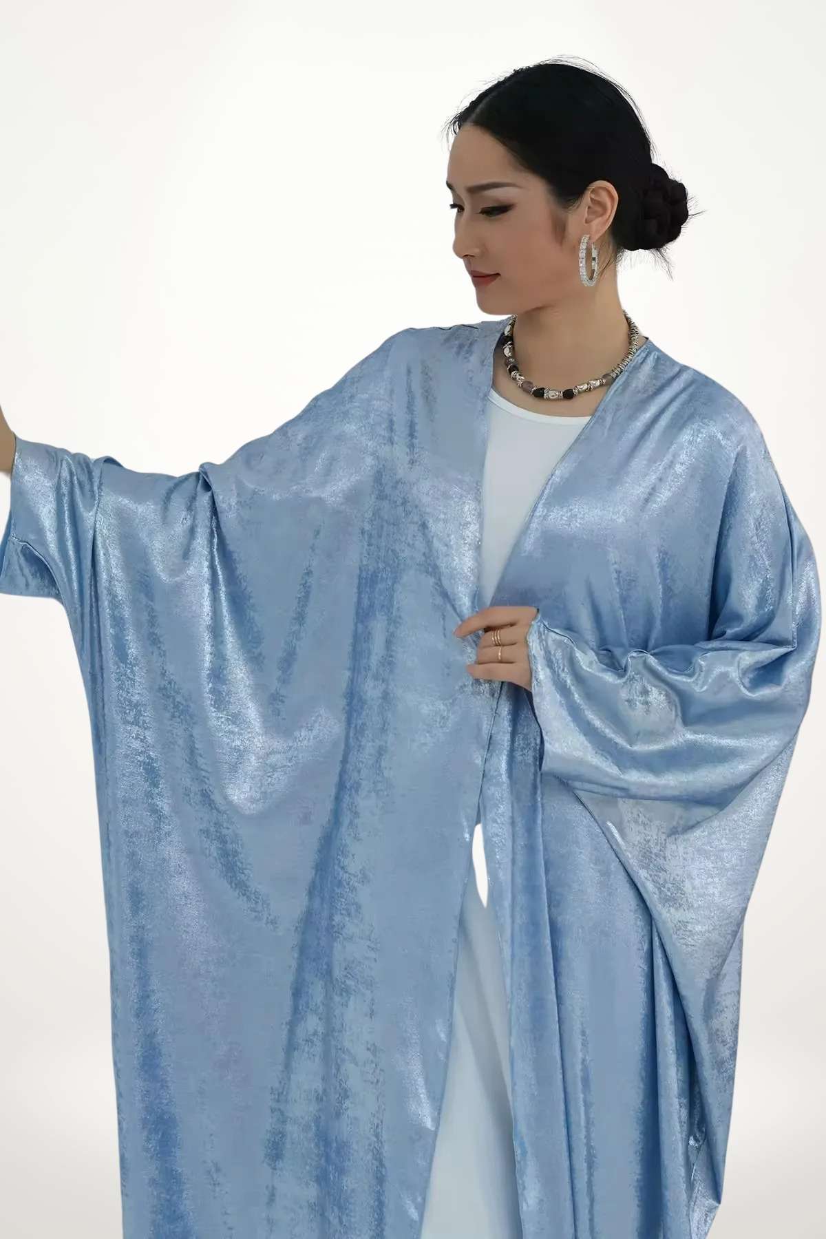 Abaya kimono satin au tissu velours texturé bleu et fluide. Design élégant et léger, parfait pour exprimer un style apaisé et contemporain.