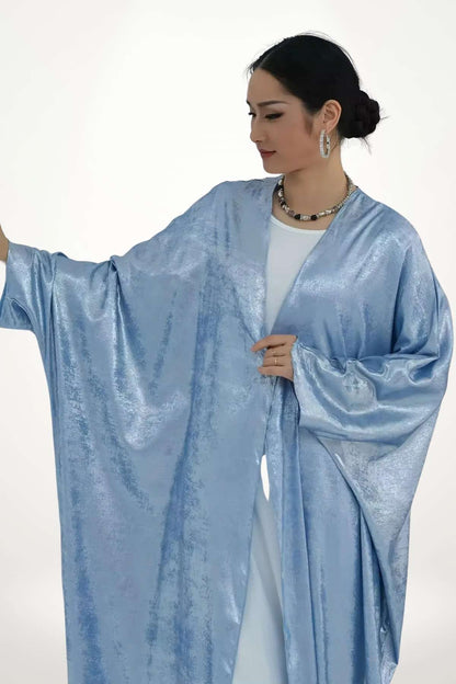 Abaya kimono satin au tissu velours texturé bleu et fluide. Design élégant et léger, parfait pour exprimer un style apaisé et contemporain.