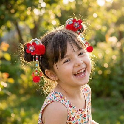 Une petite fille souriante avec des cheveux bruns ornés de fleurs rouges et de perles, dans un jardin verdoyant