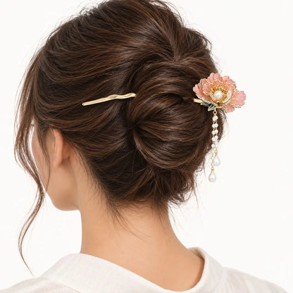 Chignon décoré d’un bijou doré à fleur et perles pendantes.