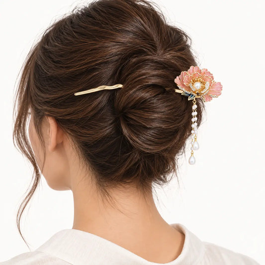 Chignon décoré d’un bijou doré à fleur et perles pendantes.