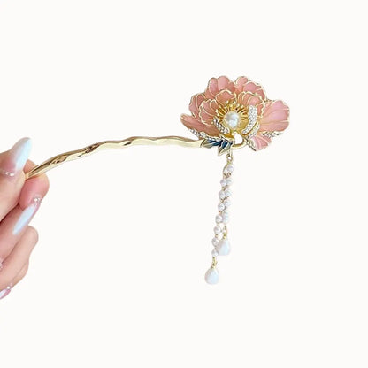 Bijou de cheveux doré avec fleur et perles suspendues.