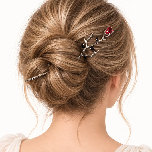 Chignon retenu par une épingle sombre ornée d’une rose rouge.