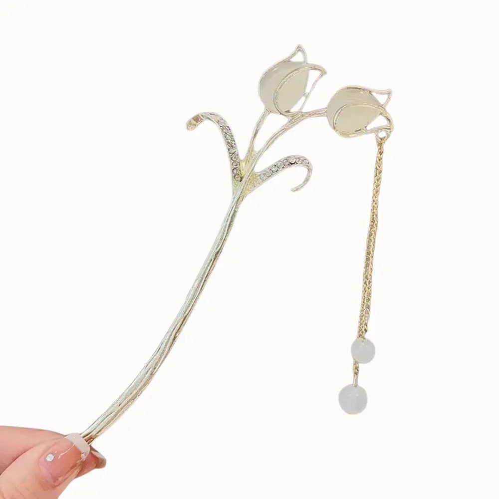 Bijou de cheveux doré avec tulipes ivoire et chaîne fine.