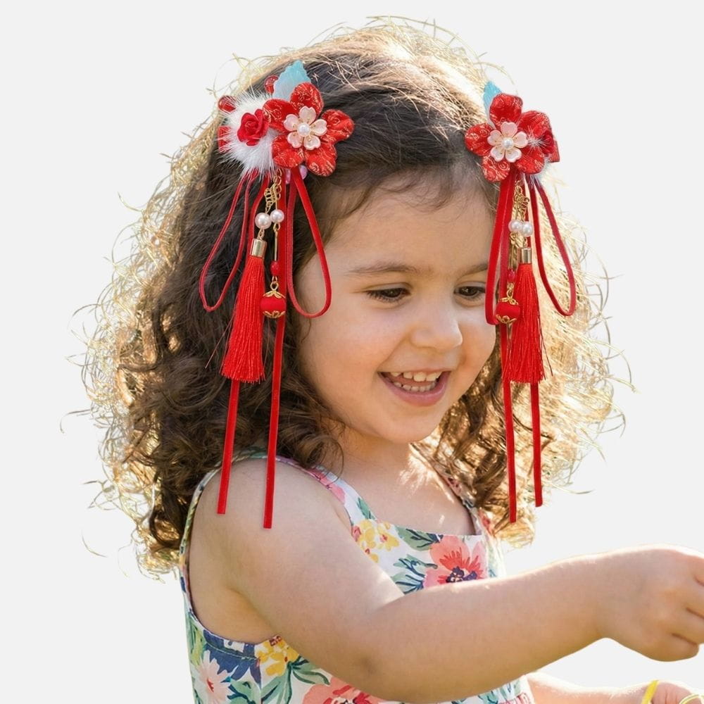 Fille souriante avec des cheveux bouclés, portant des accessoires rouges et une robe à motifs floraux colorés