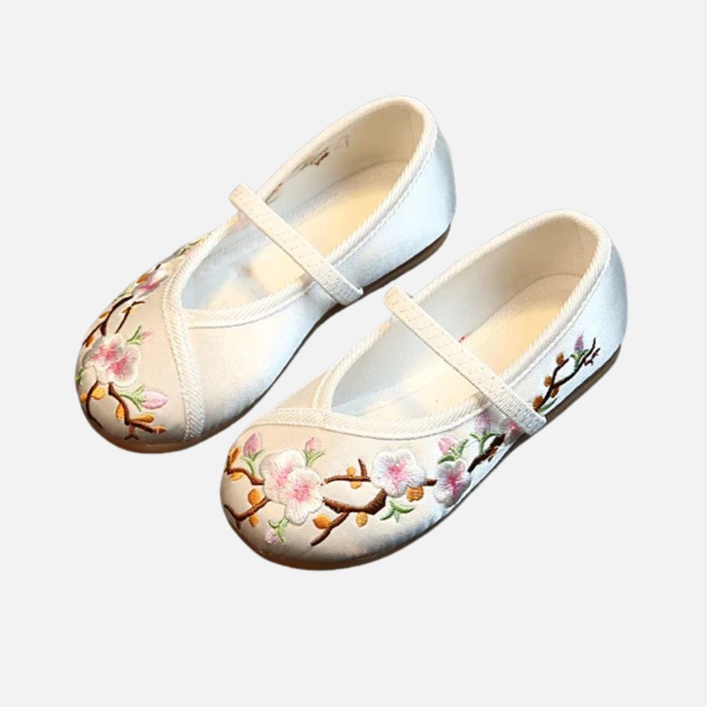 Ballerines blanches en satin ornées de fleurs roses brodées, avec une lanière délicate pour un maintien élégant