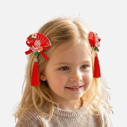 Petite fille souriante avec des accessoires en rouge et or dans les cheveux, portant un pull beige
