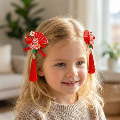 Une petite fille souriante porte des accessoires rouges ornés de pompons et de motifs traditionnels dans un décor lumineux