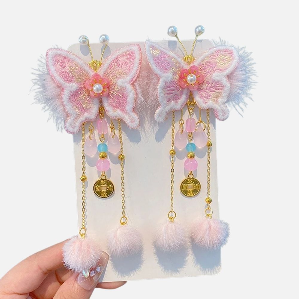 Barrette en forme de papillon rose avec des perles colorées et des pompons en fourrure douce