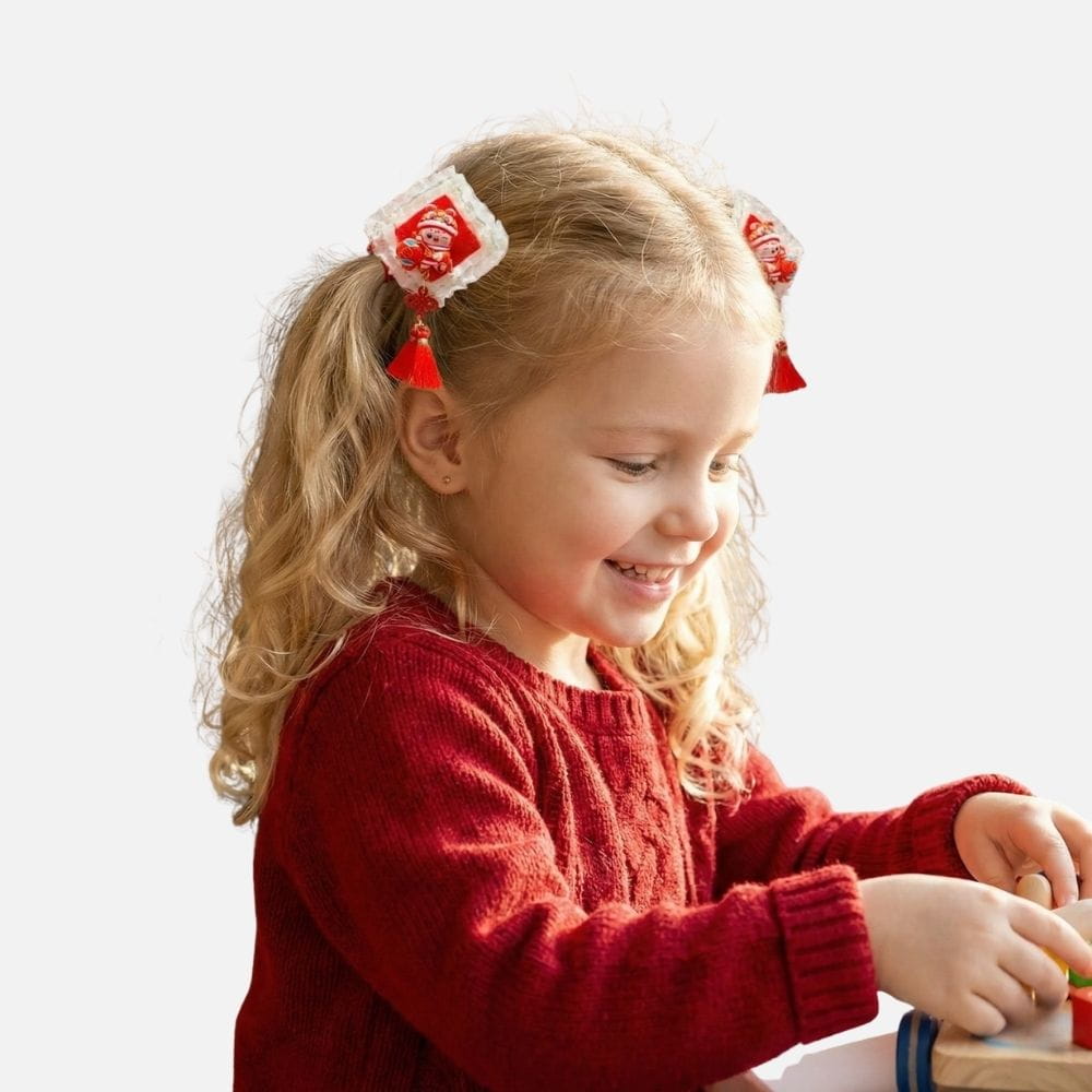 Fille souriante avec des cheveux bouclés, portant un pull rouge et des accessoires colorés dans les cheveux