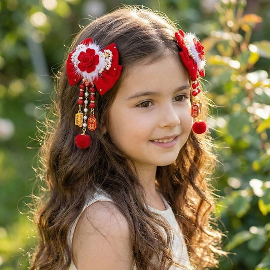 Fille souriante avec des cheveux bouclés, portant des accessoires rouges ornés de fleurs et de perles dans un jardin verdoyant