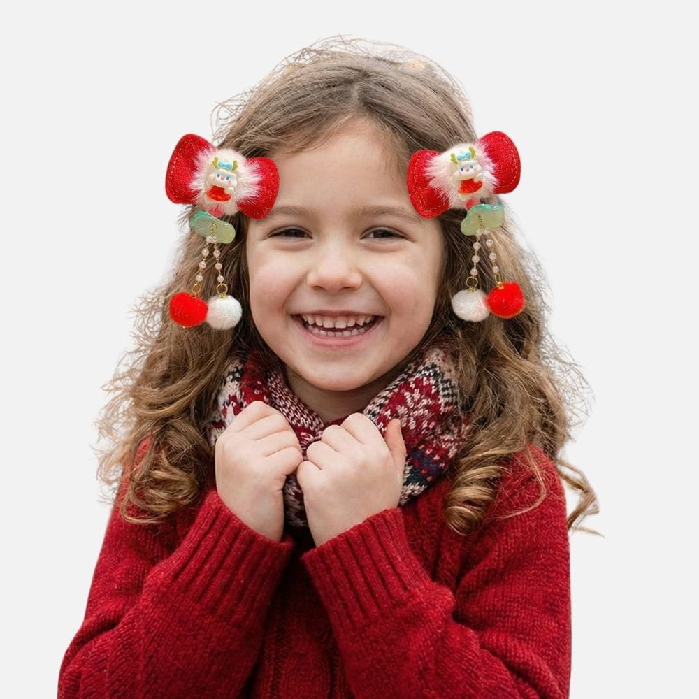Une petite fille souriante porte un pull rouge et des accessoires colorés dans les cheveux, avec un décor neutre