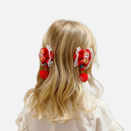 Fille aux cheveux blonds portant des accessoires de cheveux rouges avec des pompons et des motifs colorés