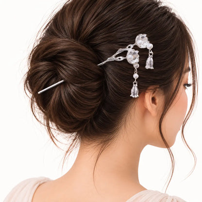 Chignon orné d’un bijou argenté à fleurs et perles.