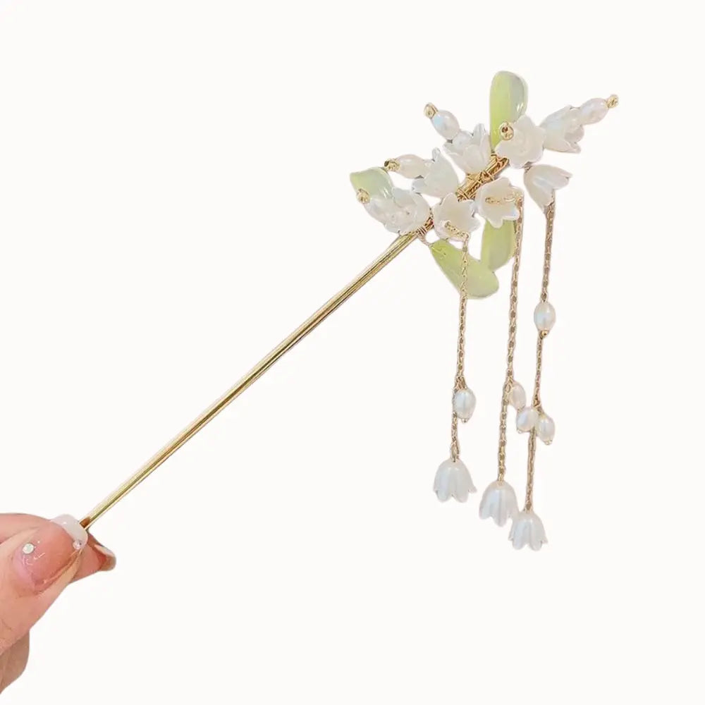 Bijou de cheveux à fleurs blanches en clochettes et rangées de perles.