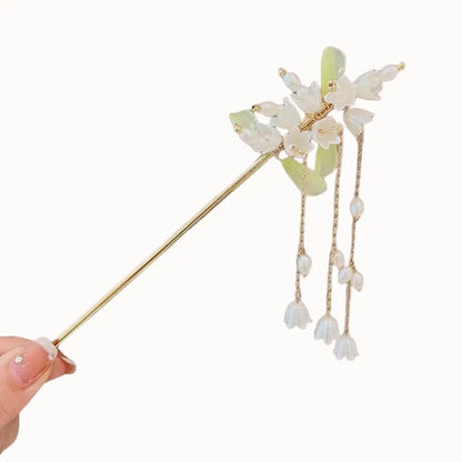 Bijou de cheveux à fleurs blanches en clochettes et rangées de perles.