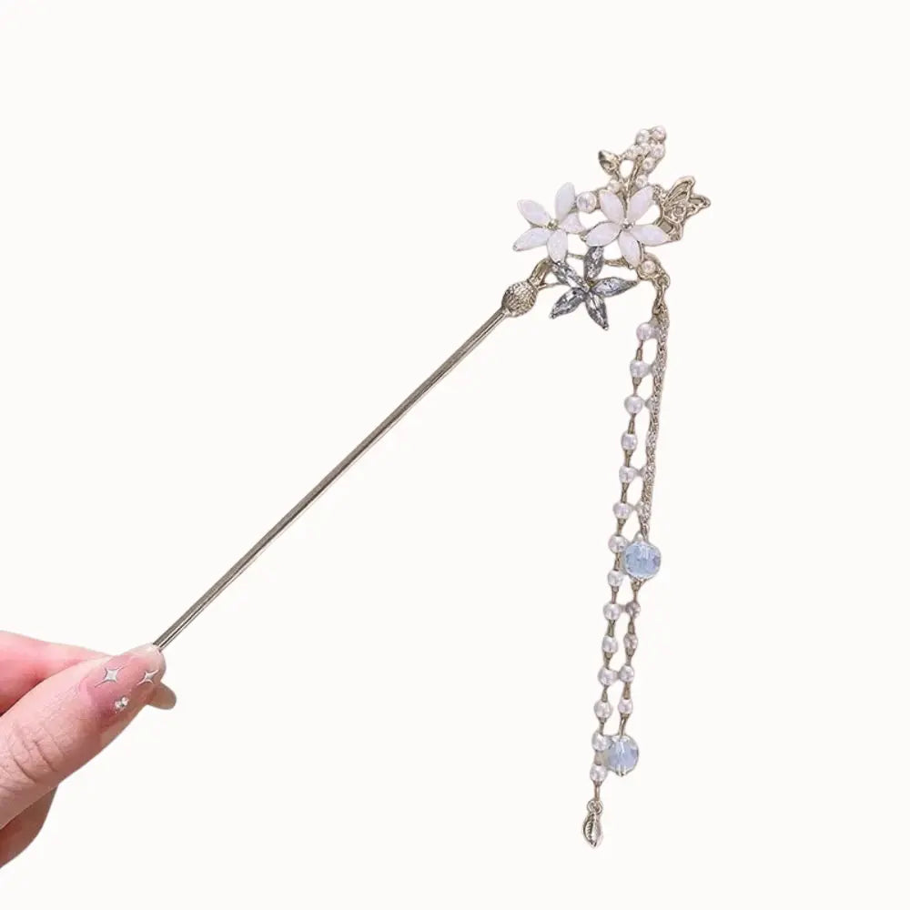 Bijou de cheveux argenté à motifs floraux et pendants de perles bleutées.