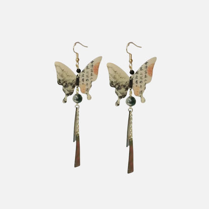 Boucles d'oreilles suspendues en forme de papillon, avec des motifs colorés et des éléments métalliques, évoquant un style japonais.