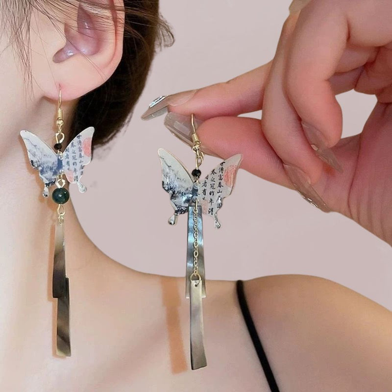 Boucles d'oreilles suspendues en forme de papillon, avec des motifs colorés et des éléments métalliques, évoquant un style japonais.