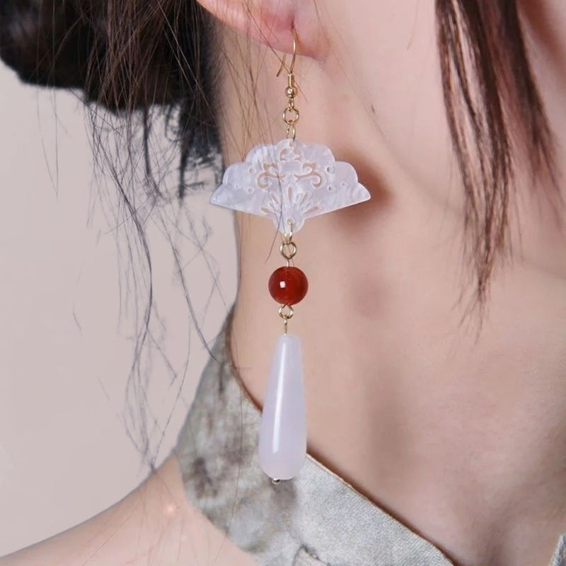 Boucles d'oreilles en forme d'éventail, avec des perles rouges et blanches, portées avec un kimono élégant.