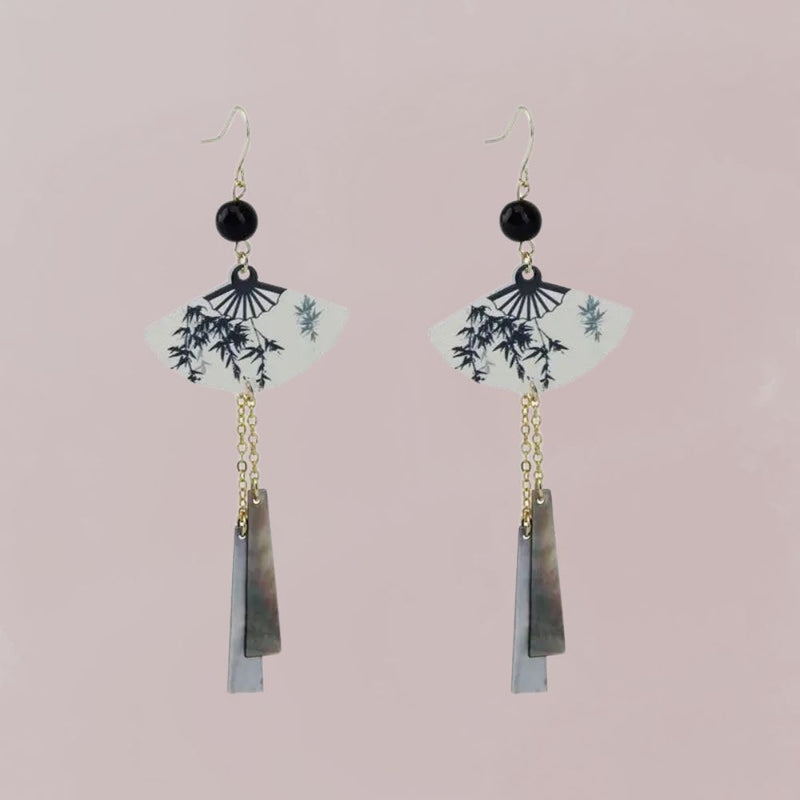 Boucles d'oreilles en forme d'éventail, avec motifs de bambou noir sur fond blanc et chaînes dorées, style japonais.