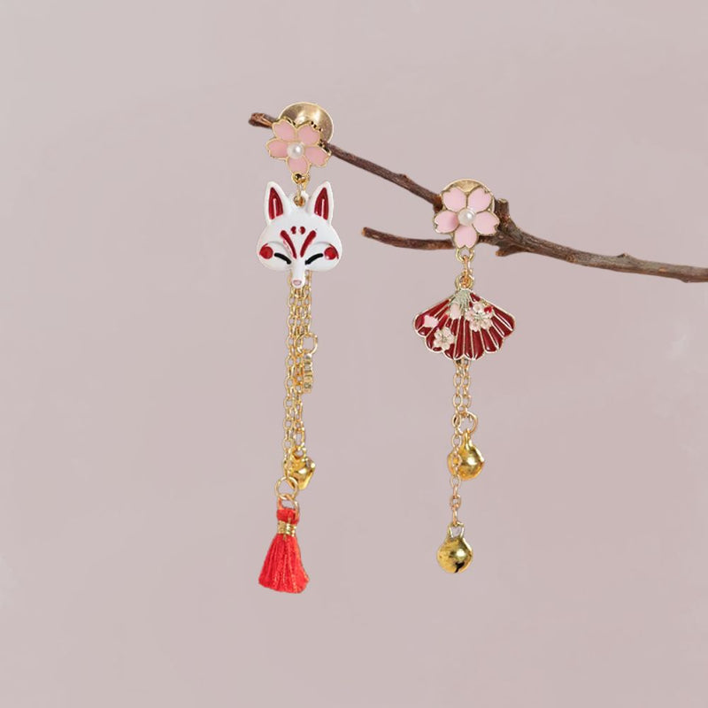 Boucles d'oreilles en métal doré ornées d'un renard stylisé et d'une fleur rose, avec des détails rouges et dorés.