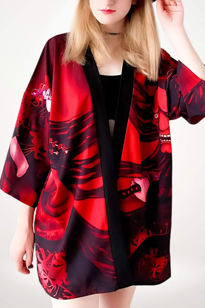 Cardigan kimono rouge avec motifs graphiques, manches larges, porté par une femme sur fond neutre