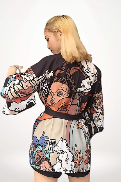 Femme portant un cardigan kimono aux motifs colorés, avec des illustrations de personnages et des nuages, sur fond blanc