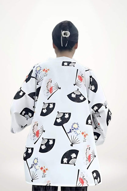 Cardigan kimono blanc avec motifs de fleurs et éventails noirs, porté par une femme vue de dos