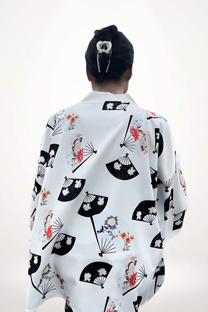 Femme de dos portant un cardigan kimono blanc avec des motifs de éventails et fleurs colorées