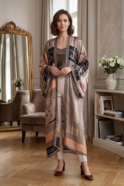 Une femme souriante porte un cardigan kimono aux motifs colorés, dans un décor élégant avec des fleurs