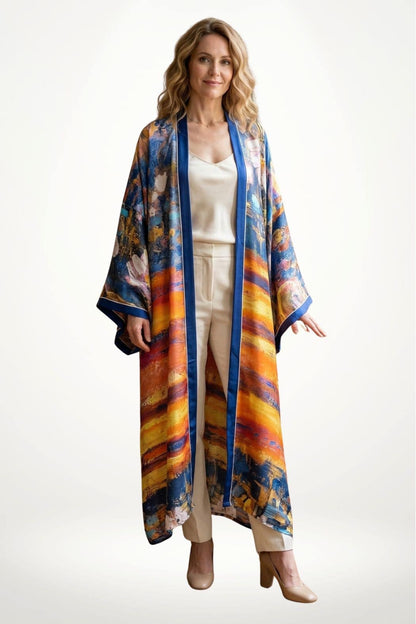Femme portant un cardigan kimono coloré avec des motifs abstraits, dans un décor minimaliste et lumineux