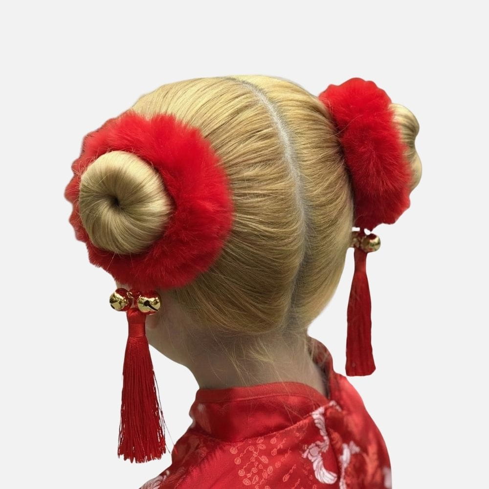 Coiffure traditionnelle avec deux chignons blonds ornés de pompons rouges et de pendants en franges
