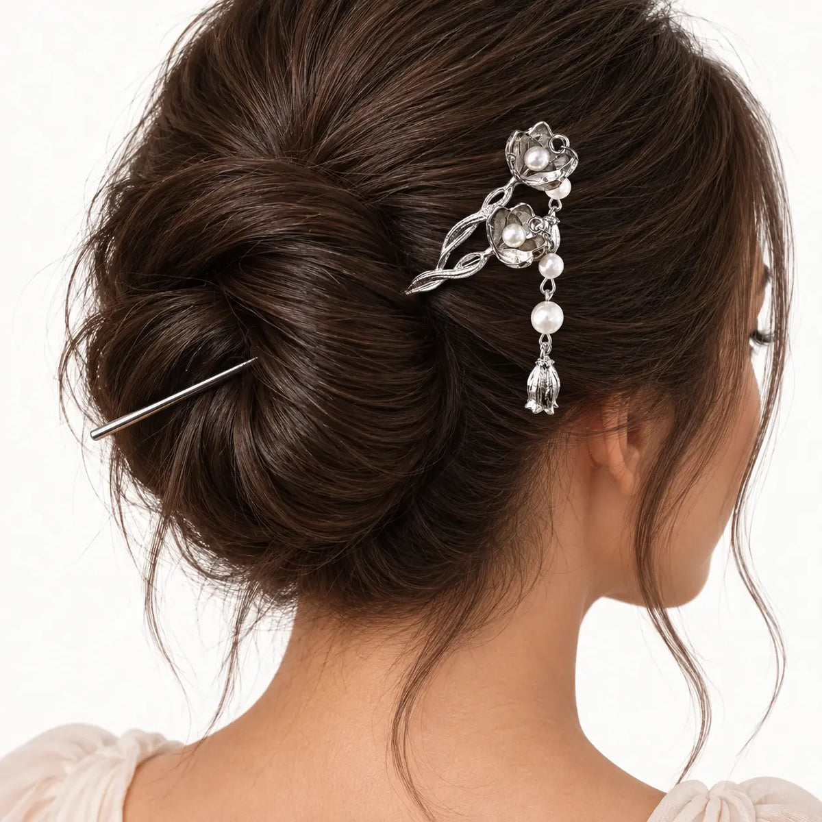 Chignon agrémenté d’une épingle argentée à fleur.