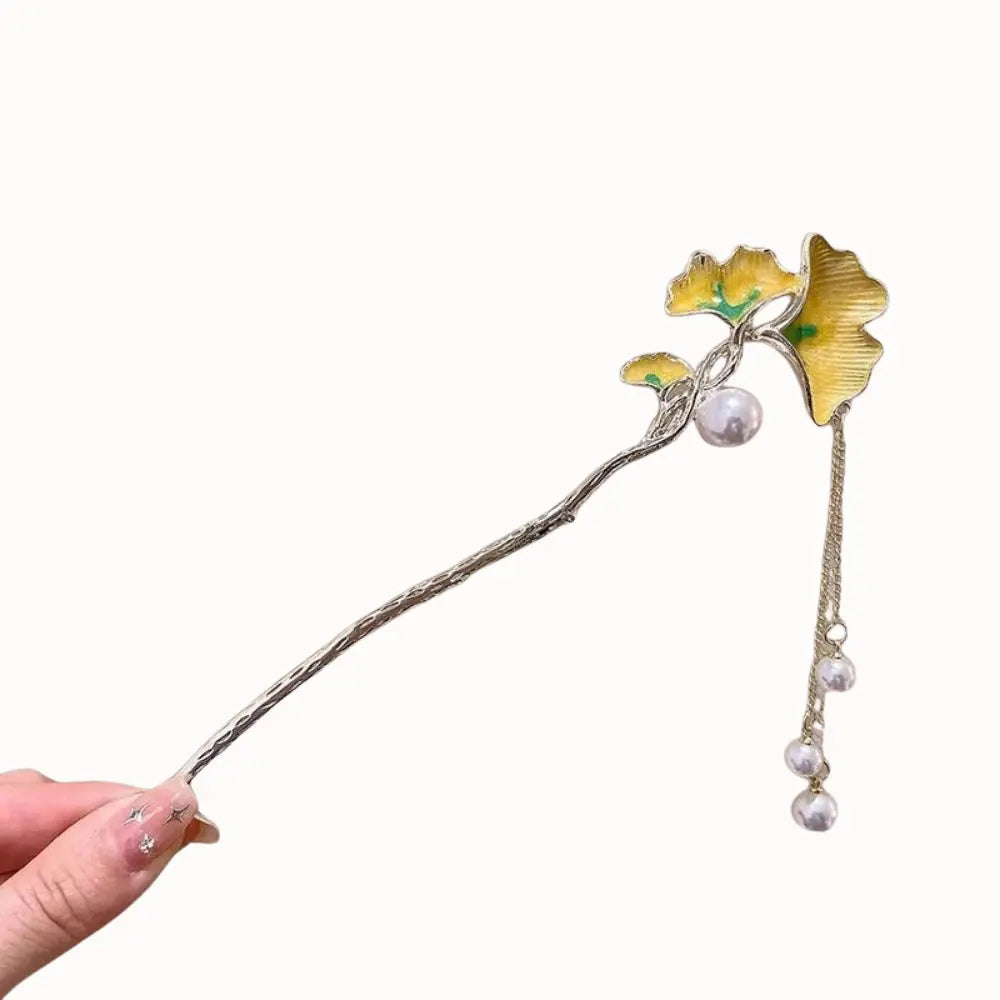 Épingle à cheveux avec feuilles de ginkgo dorées et perles.