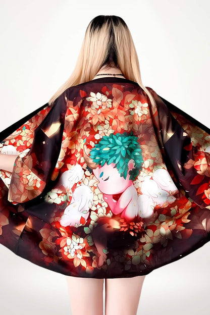 Haut kimono noir avec motifs floraux colorés, présentant un personnage mignon sur fond de feuilles rouges et dorées