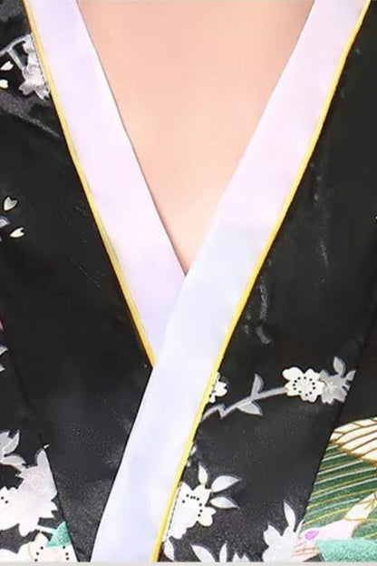 Détail du col d'un kimono noir avec motifs floraux, bordé de blanc et de jaune, sur fond coloré