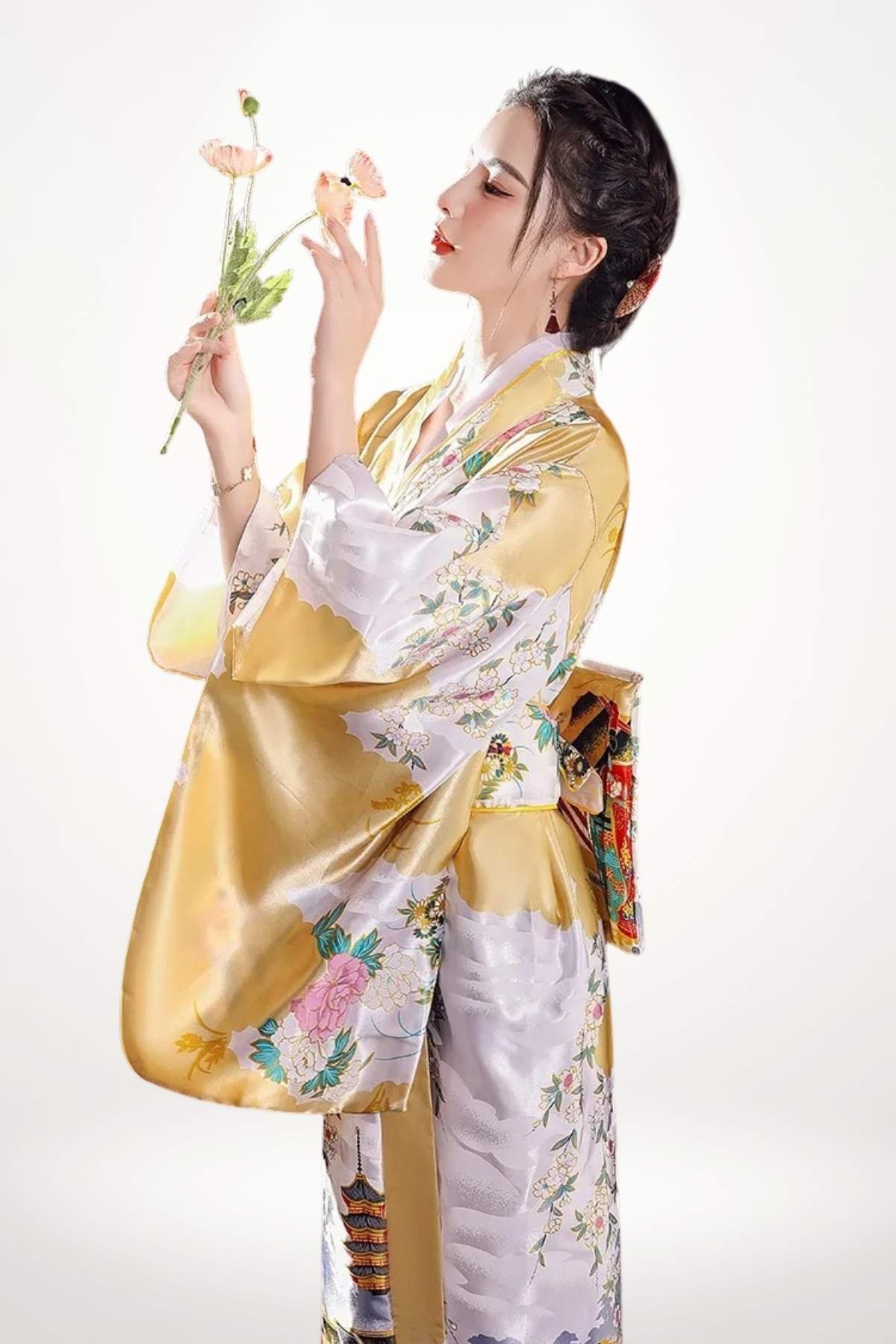 Femme en kimono jaune et blanc, décoré de motifs floraux, tenant des fleurs tout en posant élégamment