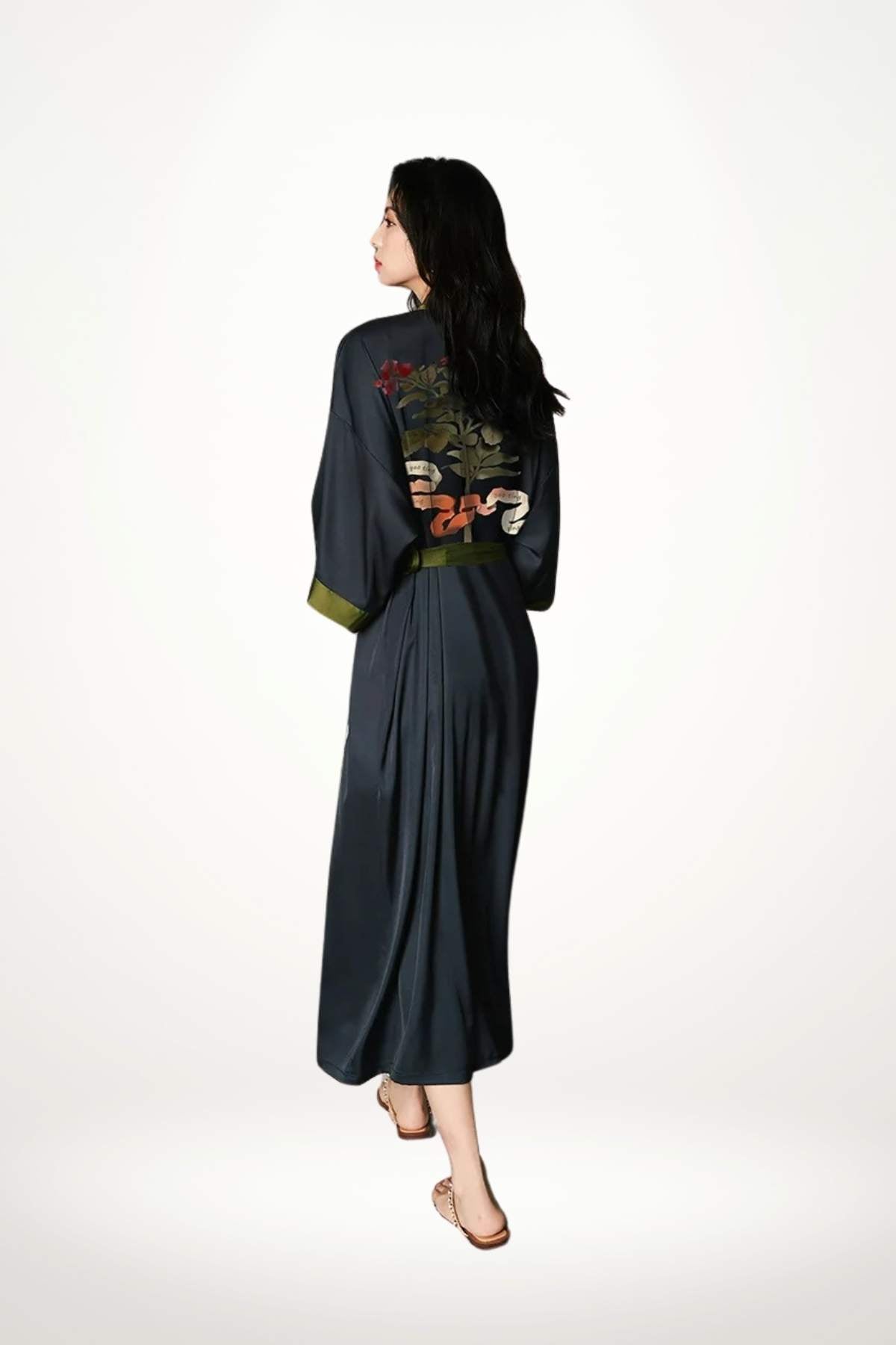 Kimono élégant à motif noir avec des détails colorés, porté par une femme aux cheveux longs, sur fond neutre