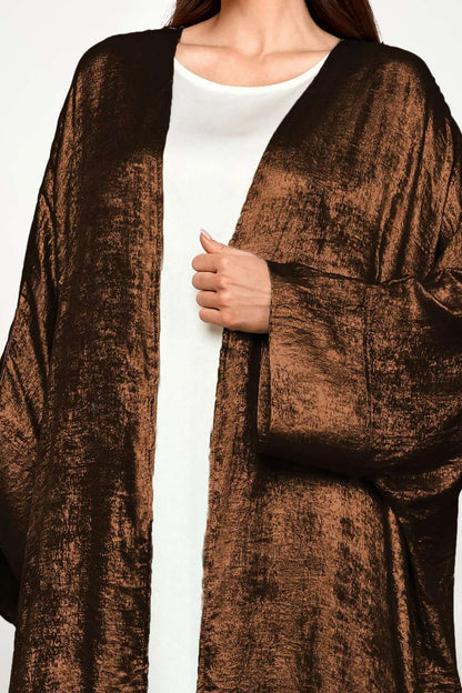 Abaya kimono satin en velours texturé marron, mélange de tradition et de modernité. Élégance fluide, coupe ample et style raffiné.
