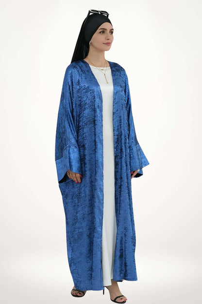 Abaya kimono satin fluide pour femme, confectionnée en velours texturé bleu. Style élégant et moderne pour exprimer une féminité pure et affirmée.