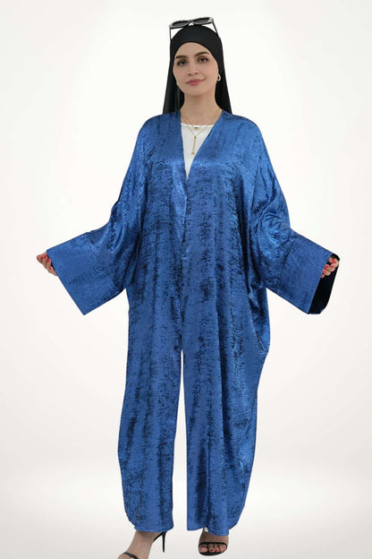 Abaya kimono satin fluide pour femme, confectionnée en velours texturé bleu. Style élégant et moderne pour exprimer une féminité pure et affirmée.