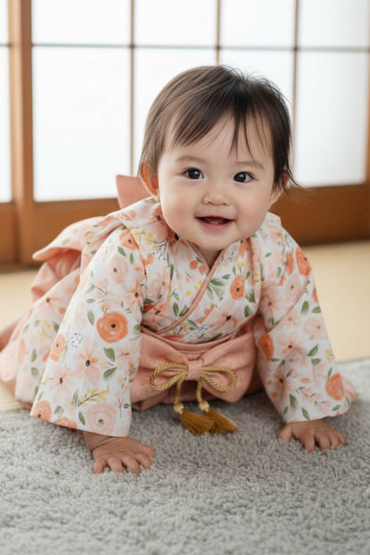 Un bébé souriant porte un yukata à fleurs pêche sur un tapis gris, dans un décor japonais lumineux