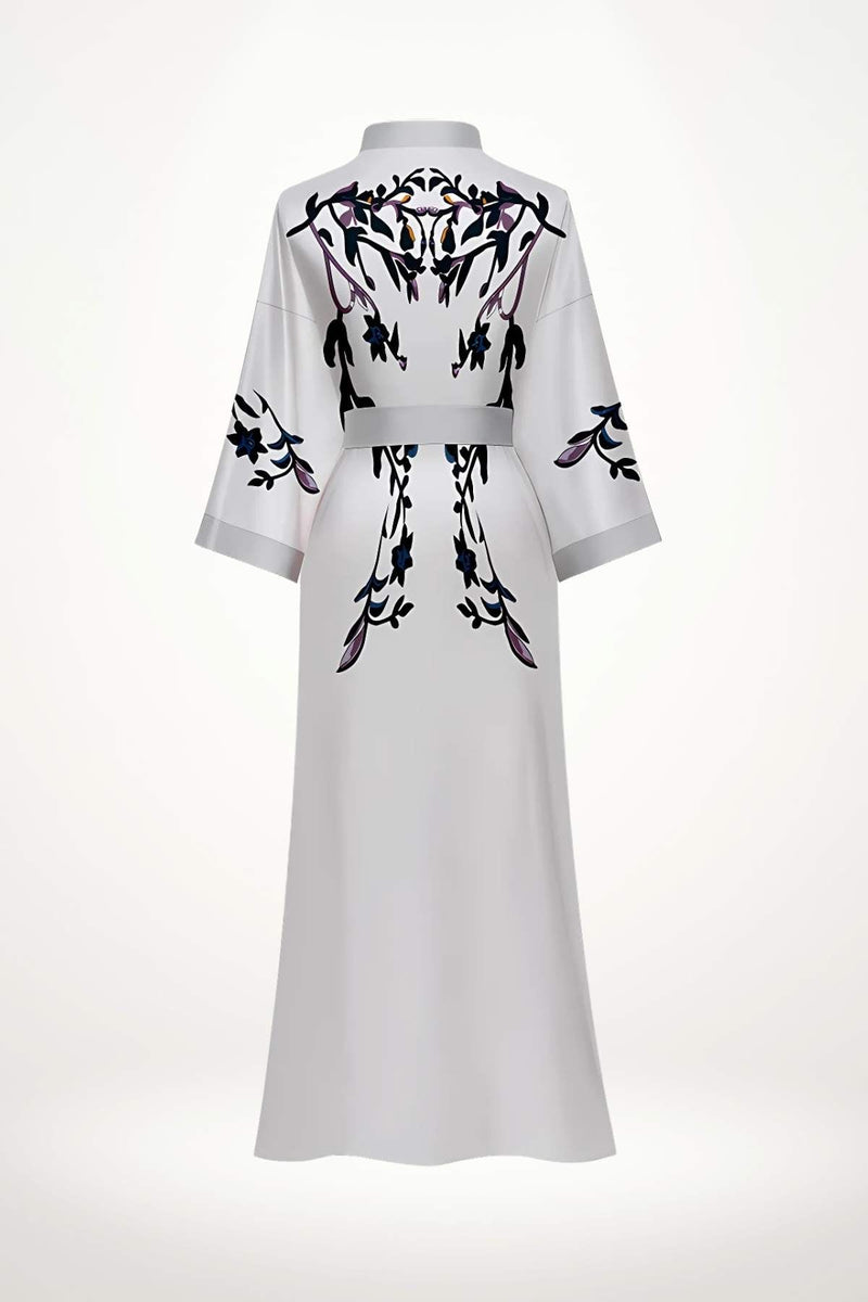 Kimono blanc avec motifs floraux noirs et violets, offrant une élégance délicate et une pureté visuelle