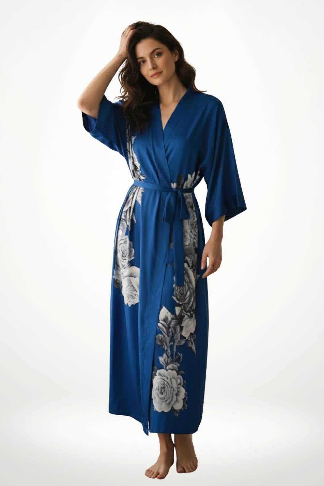 Kimono long chic en satin bleu avec motifs floraux en noir et blanc, porté par une femme debout