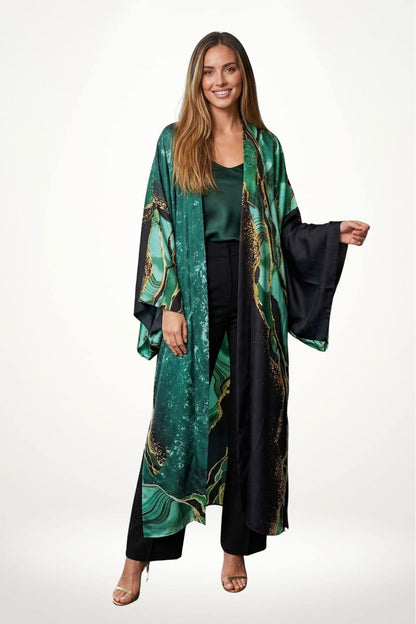 Femme souriante portant un kimono vert avec des motifs dorés, sur un fond blanc, ajoutant une touche élégante à son
