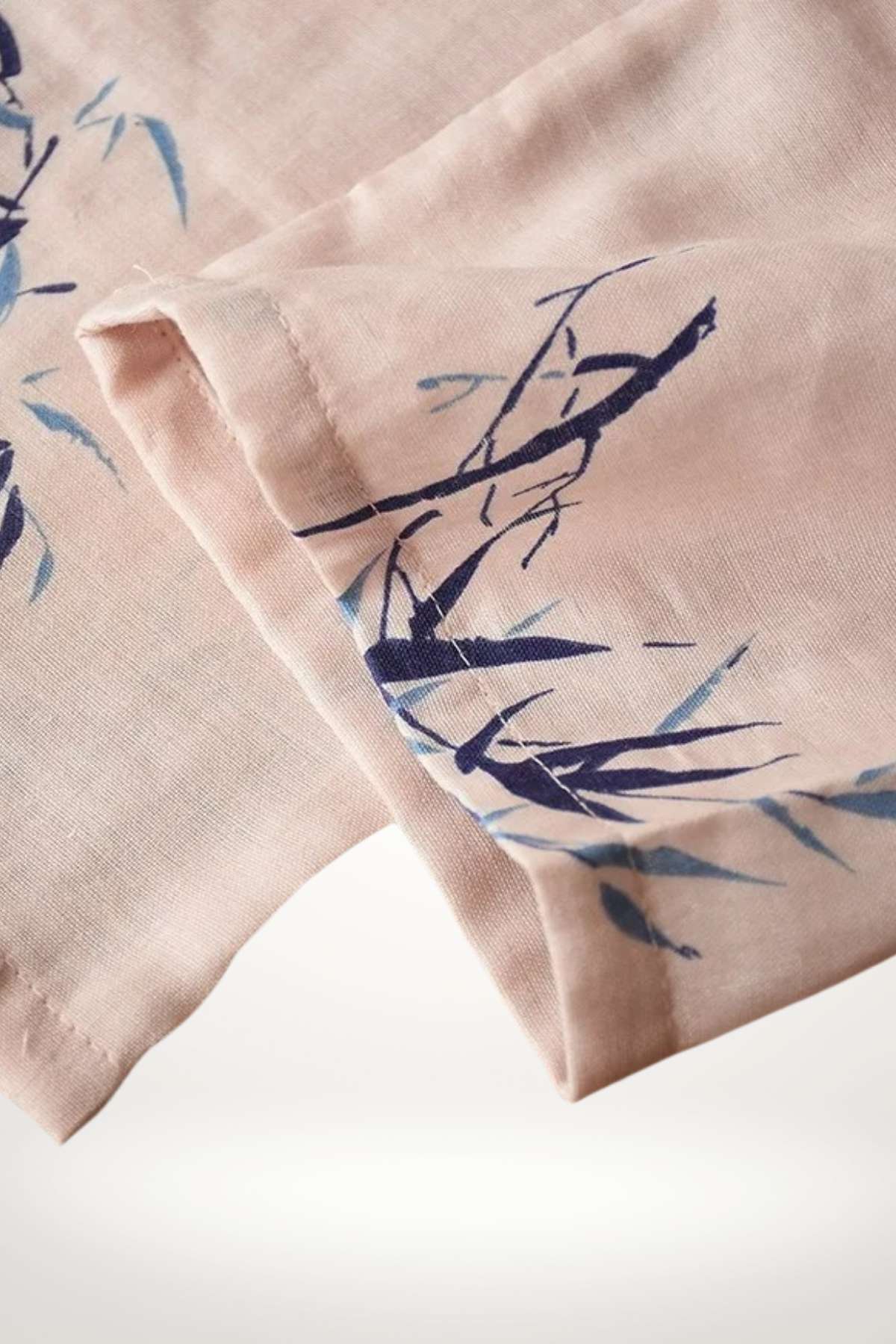 Tissu en coton rose avec motifs de bambou bleu, offrant une texture douce et légère, idéal pour un kimono