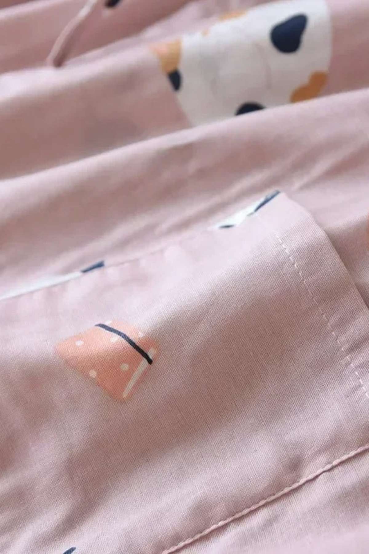 Tissu en coton rose avec motifs géométriques colorés, évoquant un style japonais doux et moderne