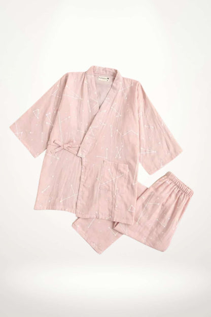 Kimono en coton rose avec motifs géométriques blancs, ceinture nouée et pantalon assorti, sur fond clair