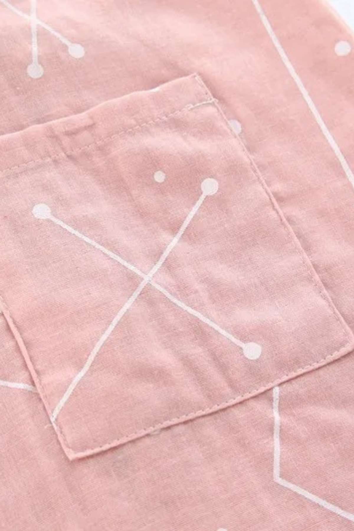 Tissu en coton rose avec motifs géométriques blancs et une poche cousue sur le côté